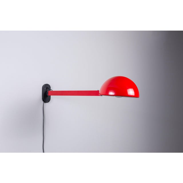 This distinctive extendable wall lamp combines bold colour with ingenious functionality. Crafted from red lacquered metal,...
