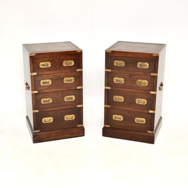 A smart and extremely well made pair of antique military campaign style bedside chests with leather tops. They were made...