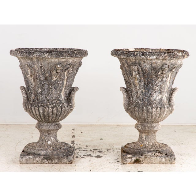 A striking pair of early 20th-century English concrete stone urns reminiscent of the style of Andrew Handyside. The wide...