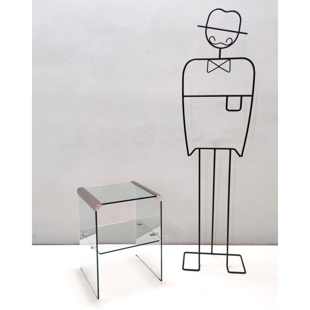 Made in Italy, 1970s - 1980s. This etagere / side table is made in tempered glass and features a glass shelf and steel...