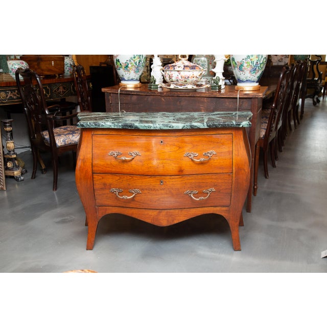 This is a very quiet French Louis XV fruitwood bombe commode. The Verdi green marble top rests over two long drawers. the...