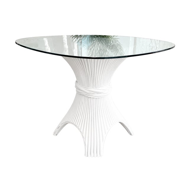 A vintage sculptural rattan pedestal table featuring an elegant fluted base with a distinctive wrapped center detail and...