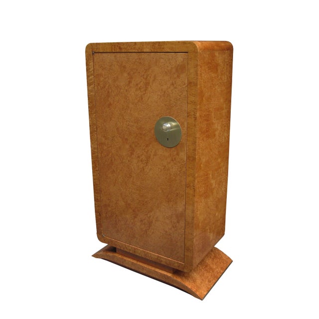 A pair of Art Deco tall cabinets. Amboyna with patinated bronze and glass details. Each cabinet shelved with a single...