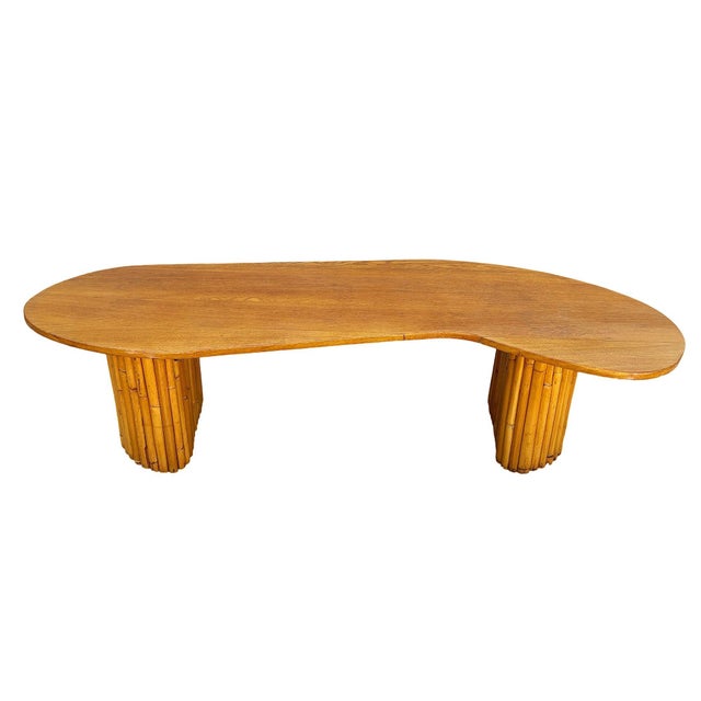 This beautifully rattan and mahogany asymmetric J-shaped coffee table with stacked rattan pedestal legs, commonly known as...