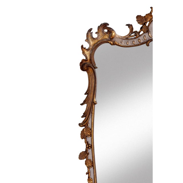 Large early 20th‑century painted and gilt wood mirror featuring an ornate crest and an elegant, curved frame. The surface...