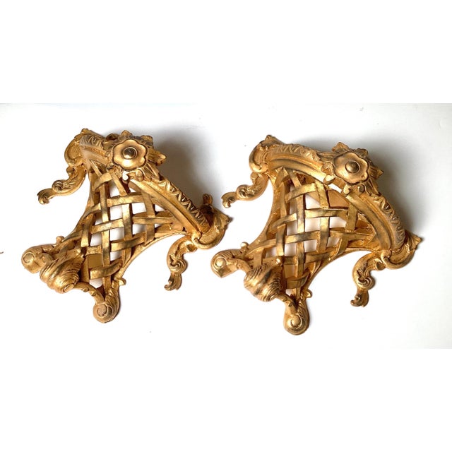 An unusual pair of Italian made gilt wood wall shelves. The Louis XV style with a lattice work center with Demilune top...