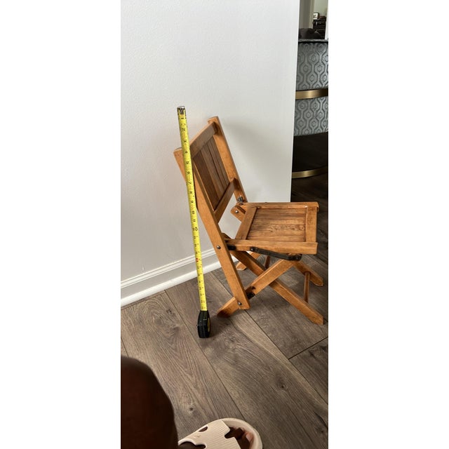 This is a vintage wooden slatted folding chair, similar to styles produced by ACME or Paris Manufacturing Co. The folding...