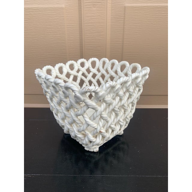 An elegant trompe l'oeil porcelain cachepot crafted in the form of a handwoven rope basket. Executed in glossy white...