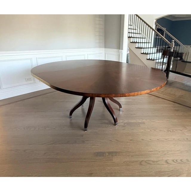 Round swirled mahogany veneer top, on six- legged spider leg pedestal base with nickel plated feet. 30 in. H., 60 in....
