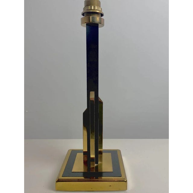 The lamp is made in the contrasting colors golden brass and black, the column has the shape of a skyscraper. An item with...