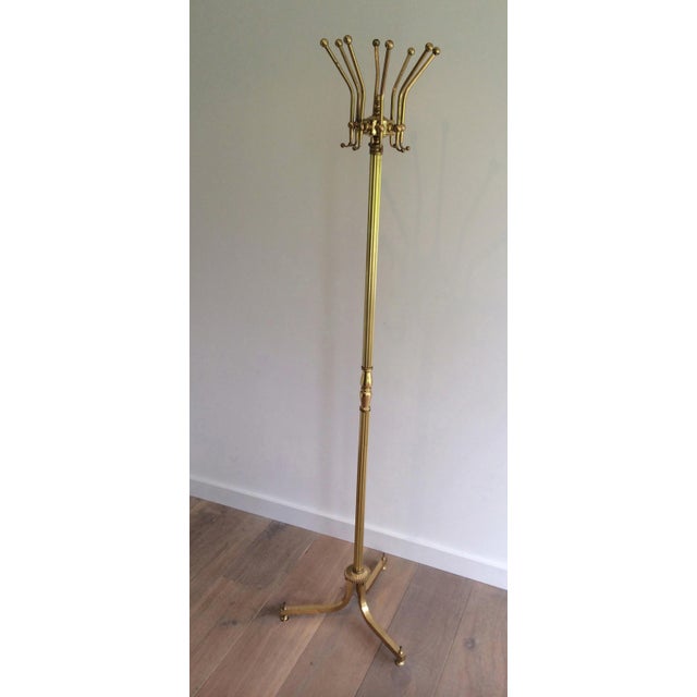 This beautiful and elegant neoclassical-style coat rack is made entirely of brass. It is a French piece. Circa 1940