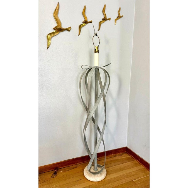 Substantial vintage floor lamp with sweeping metal ribbons that loop into a loose bow and spiral around a central column....