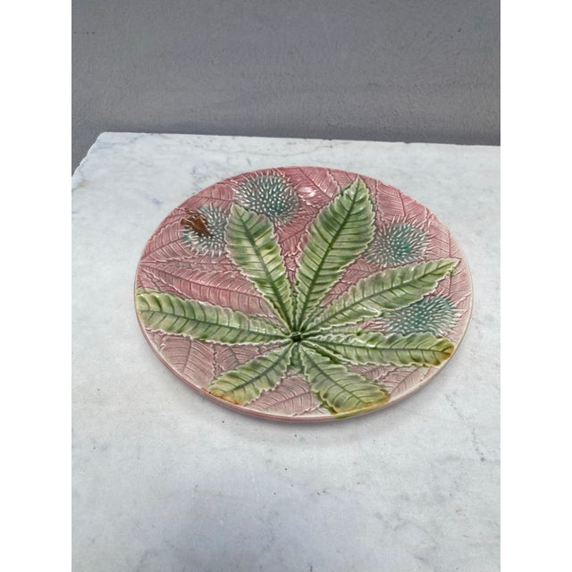 Majolica chestnut leaves plate Salins, circa 1880, on a pink background.