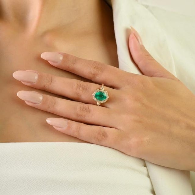This luxurious statement cocktail ring features 1 oval cut natural emerald totaling 1.69 carats, set in luxurious 14K...