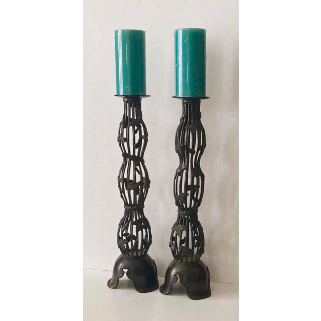 Tall patinated bronze cage style candle stands. Beautifully detailed with leaf embellishments. They accommodate pillar as...
