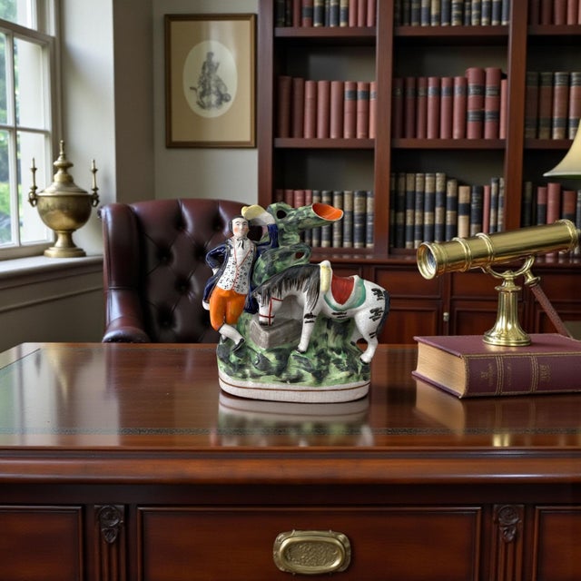 A charming and sculptural English Staffordshire figural piece depicting a standing gentleman beside a saddled horse at a...