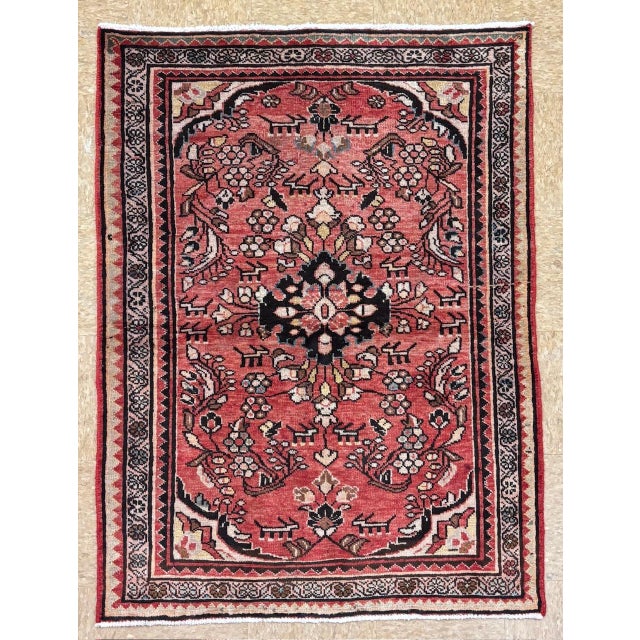 Hand-knotted village rug from the Hamadan region of western Iran, featuring a central floral medallion set within a...
