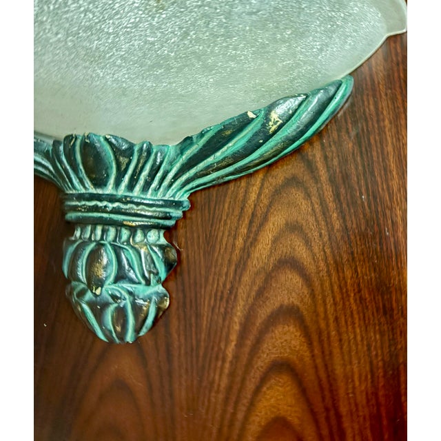 A pair of Danish Art Deco wall sconces in molded clear frosted glass shades with flowers motif details mounted in a...