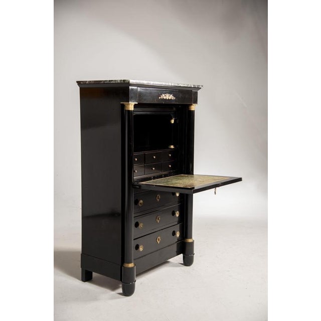 A restored Napoleon III writing desk from the late 19th century with an ebonized wood finish. The top is marble, and the...