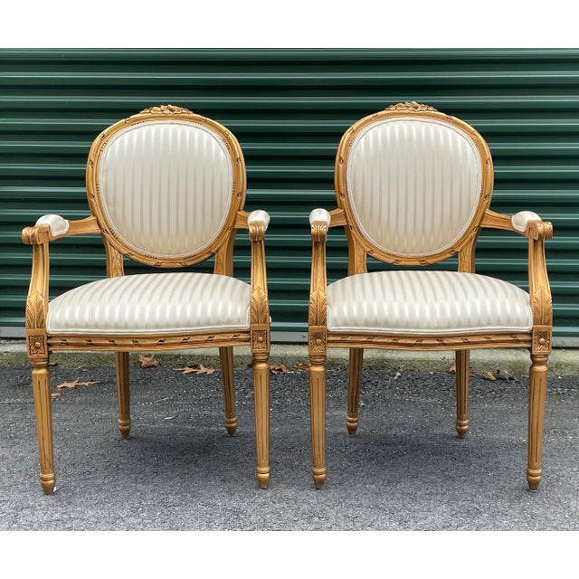 A pair of gold Louis XVI side or occasional chairs by Andre Originals. Seat height is 19.5”. Arm height is 27.25”.