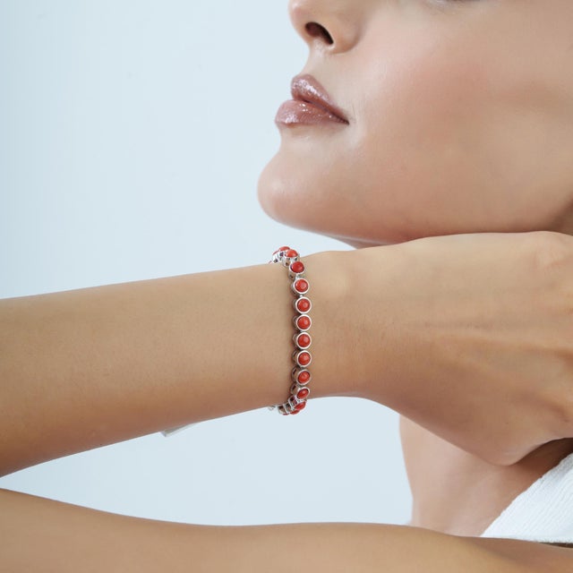 The Carat&Her Natural Red Coral Tennis Bracelet features 10.57 carats of round red coral cabochons set in polished 925...
