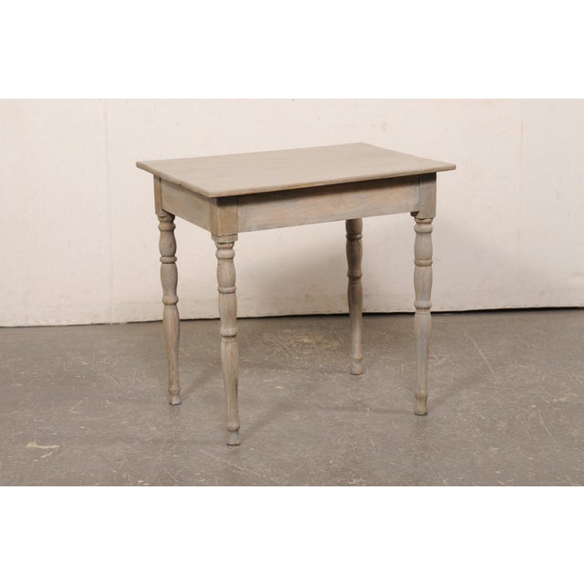A French painted oak side table from the 19th century. This antique table from France has a rectangular-shaped top, which...