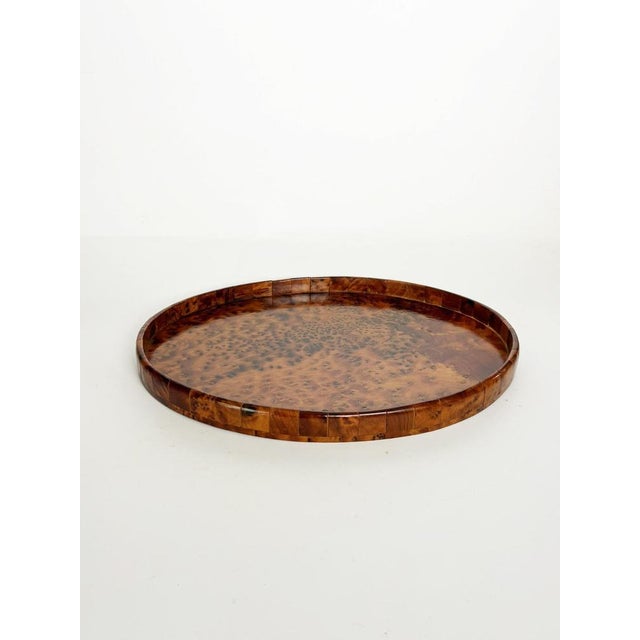 An elegant wooden serving tray featuring stunning burl wood veneer; the rich, nuanced grain patterns create a particularly...