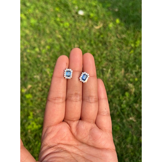 These stud earrings feature a 1.3‑carat natural octagon blue sapphire and diamond set in 14K yellow gold. Each earring...