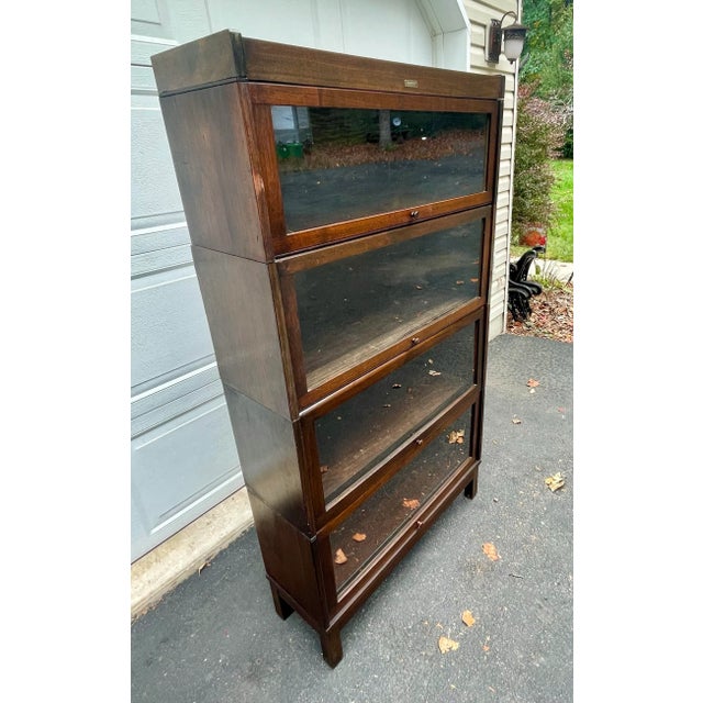 Offered is a four stack bookcase in mission oak. It was manufactured by the C. J. Lundstrom Manufacturing Company. The...