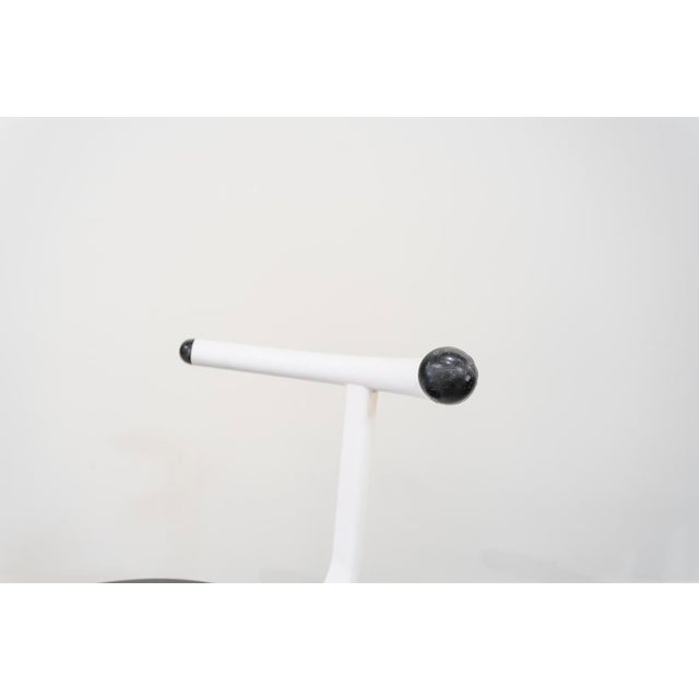 Chairs with a minimalist white aluminum tubular frame, with a semicircular backrest finished in two black balls and a...