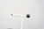 Chairs with a minimalist white aluminum tubular frame, with a semicircular backrest finished in two black balls and a...