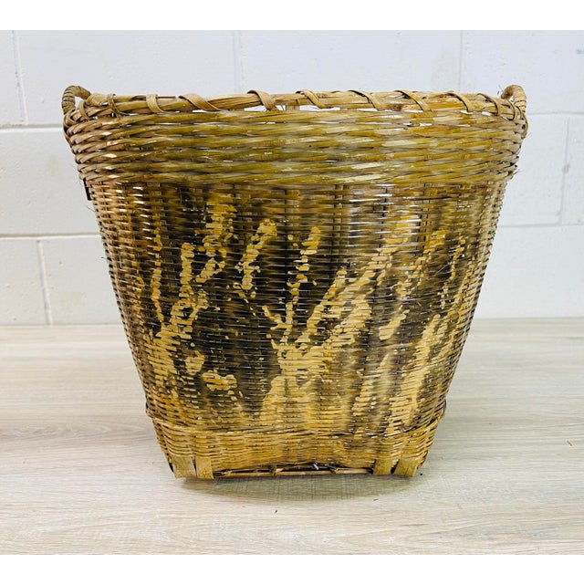 Vintage 1970s round wicker basket with handles and a burnt abstract design. No marks.