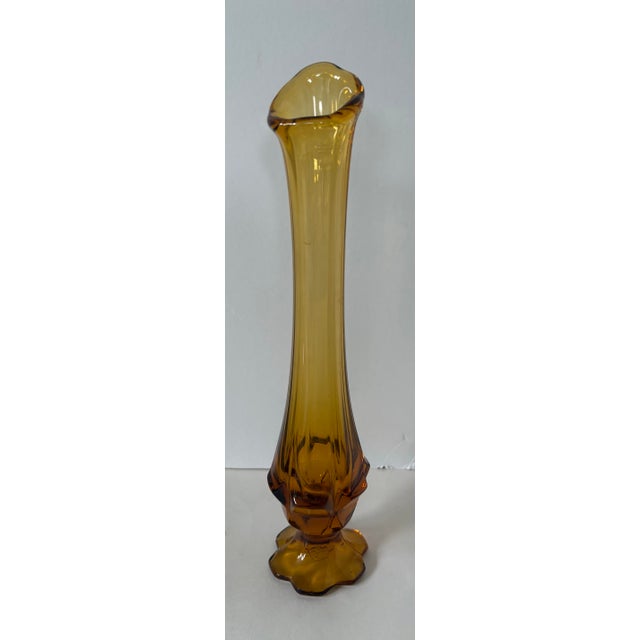 Elevated amber glass vase with a tall, sculptural silhouette, softly flared rim, and mid century modern feel. The...