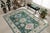 Isla Kazak Green Hand Knotted Wool Rug, Country of Origin: India. This exquisite piece captures the robust geometric...
