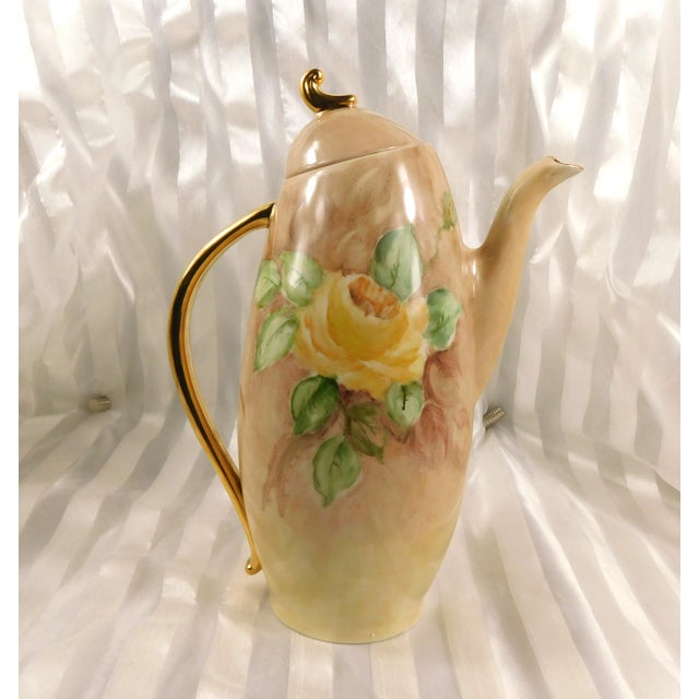 This is a tan hand painted and signed chocolate pot, teapot or coffee pot. The pot is a tan color with yellow roses and...
