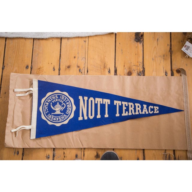 Solid blue background with white detailing and lettering featuring a graphic of an encircled oil lamp with the word...