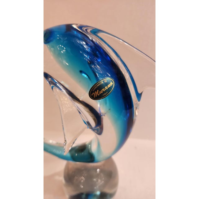 This listing features a Murano glass dolphin sitting on top of a clear glass sphere. While the sculpture is mostly...