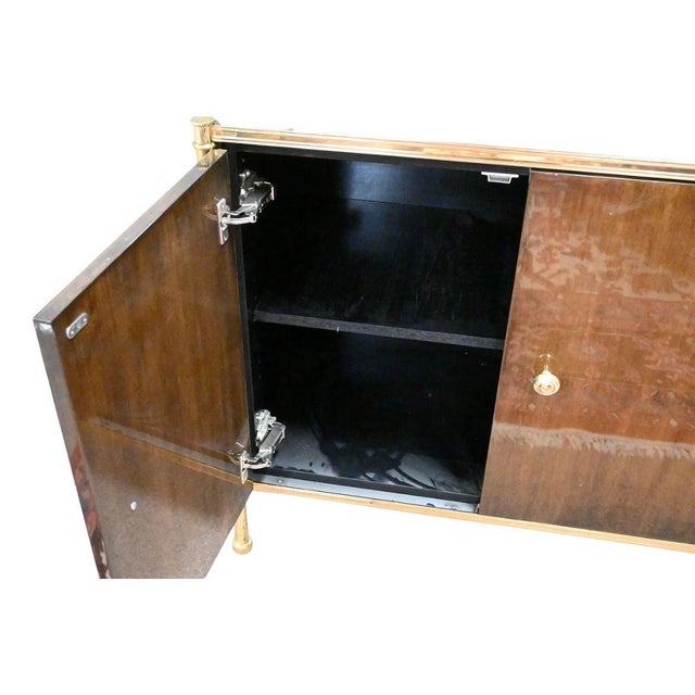 A Billy Baldwin étagère cabinet, a mid-century polished brass and lacquered mahogany modular shelving system with a three...