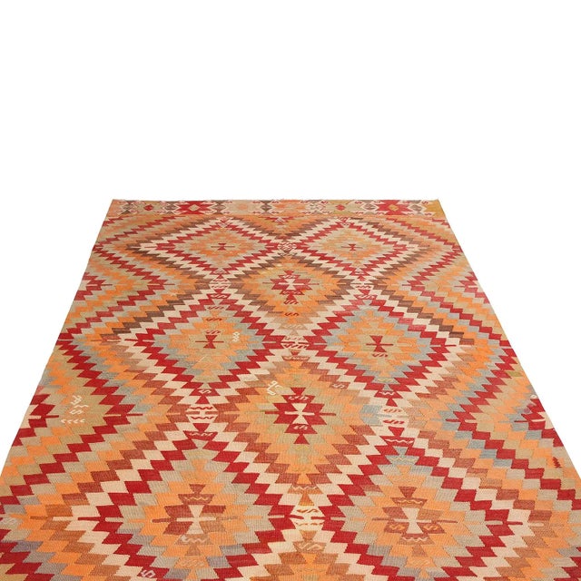 Flat-woven in high-quality wool originating from Turkey between 1940-1950, this vintage hand-woven Kilim rug enjoys an...
