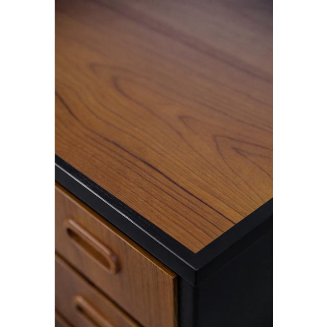 This classic desk was made in Sweden during the 1960s. It is made of brown-gold teak with black elements. Teak wood is...