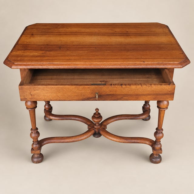 A refined 20th-century Louis XIII style writing table featuring a molded rectangular top, single locking drawer, finely...