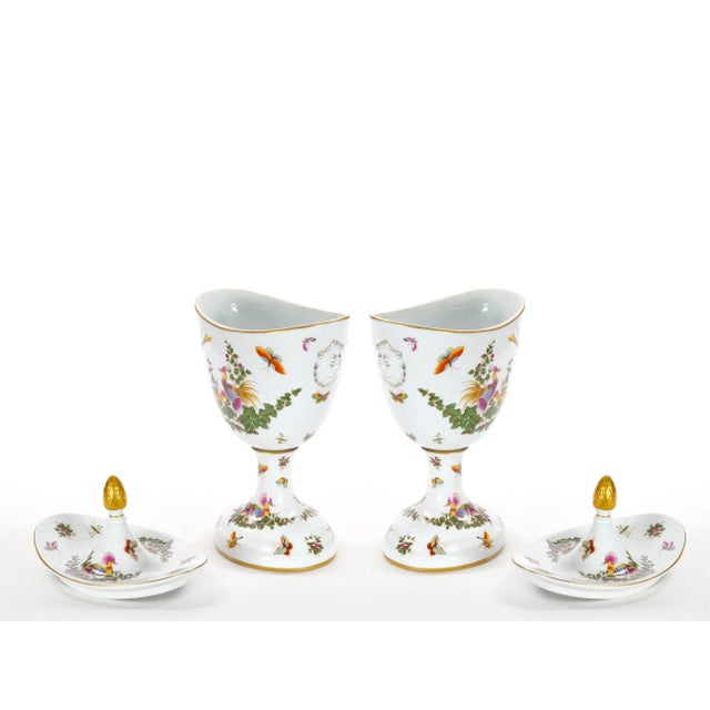 These exquisite Mid 20th Century hand painted and gilt decorated covered decorative urns showcase a stunning array of...