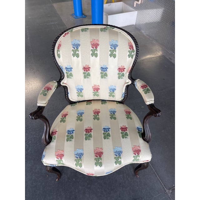 Elegant pair of Louis XV style armchairs featuring carved hardwood frames with graceful cabriole legs and scrolled arms....