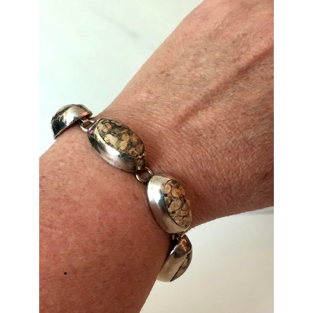 This lovely Mexican Jasper Cabochon Sterling Link Bracelet consists of seven oval jasper stones wrapped in silver and...