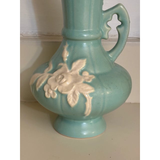 Vintage Weller Pottery Urn Vase Green White Flowers. Naturaly occurring blemish near rear of mouth. Bottom near signature...
