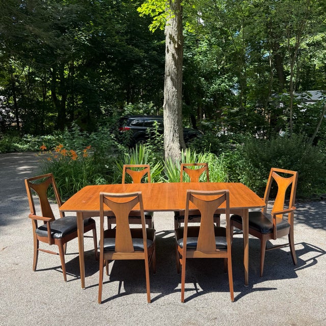 Kent Coffey Perspecta dining set featuring the collection’s unmistakable sculptural silhouette and walnut construction....