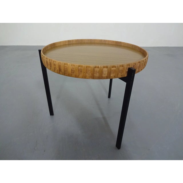 This is a small table with a removable tray on a black painted metal frame.