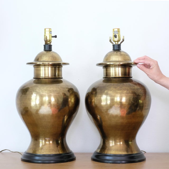 Set of two large MCM brass ginger jar lamps, in good overall condition. Both are in working condition. One of the lamps...