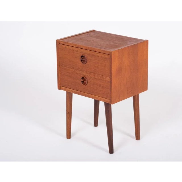 Bedside table / two drawer dresser in teak with pig snout grips and slanted legs. Good storage room in drawers. The...