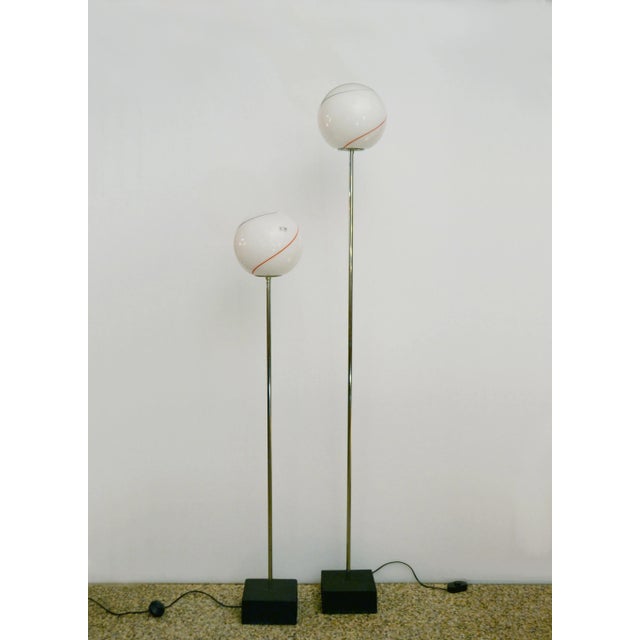 A pair of 1970s floor lamps manufactured by Leucos with the makers' label. In blown glass with applications of colored...